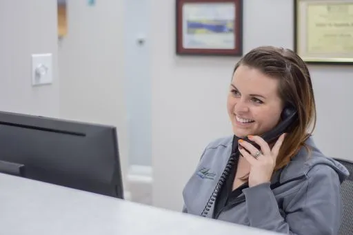 Staff member answering the phone at the front desk