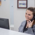 Staff member answering the phone at the front desk